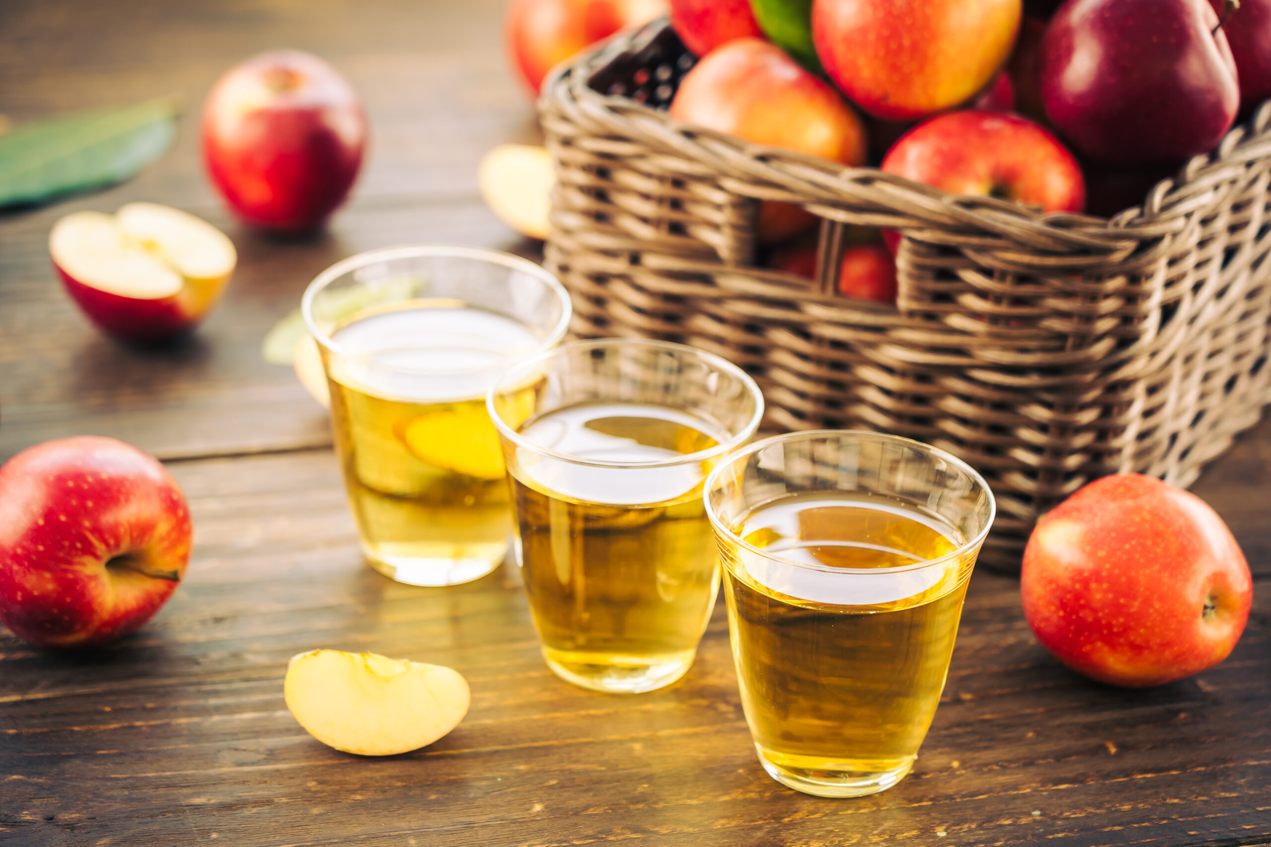 Apples juice in glass with red apple in the basket - Healthy food and drinking concept